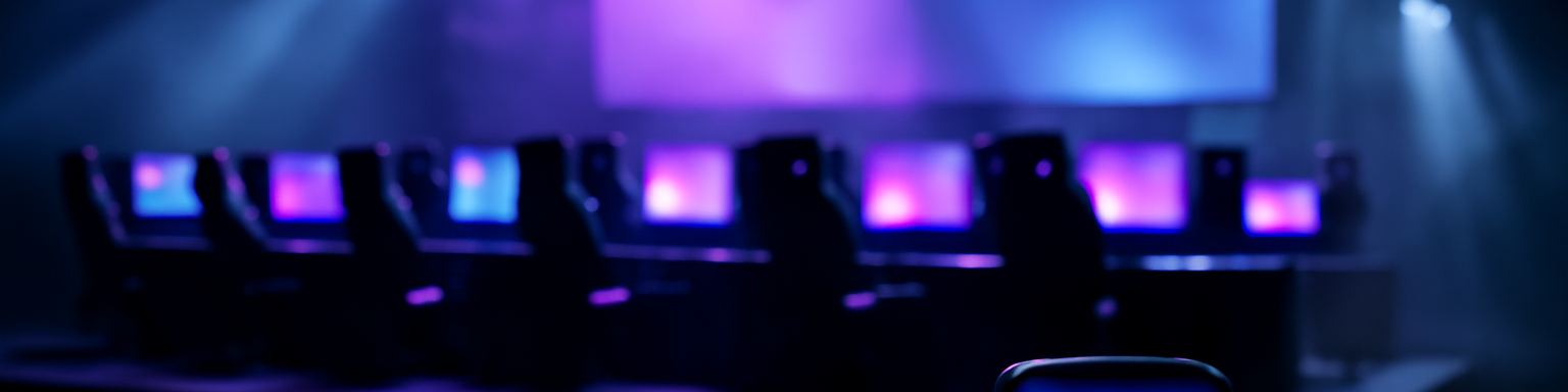 Escenario de un torneo de esports con filas de ordenadores iluminados en violeta y turquesa, imagen de esta comparativa de casas de apuestas de esports